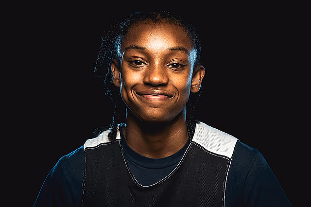 California Storm player smiling in a dark studio portrait.