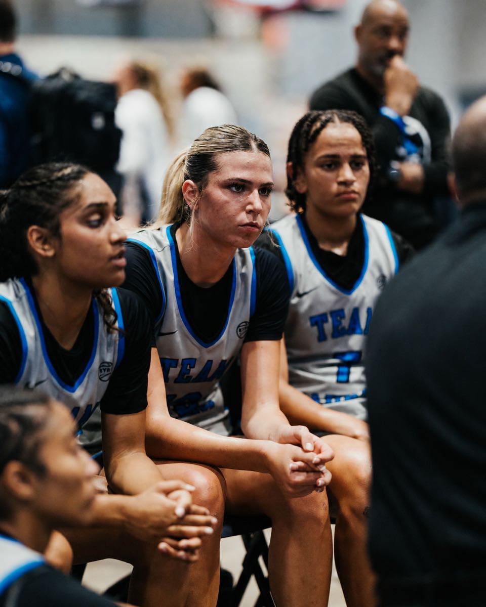 Team Taurasi players lean forward and listen together during a timeout huddle