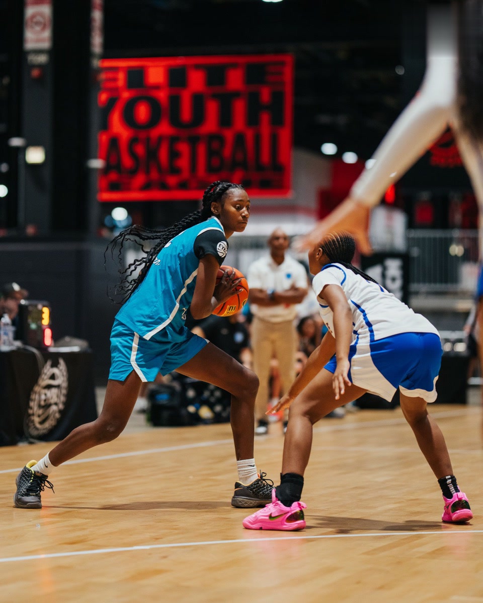 Team Taurasi player reading a defender while protecting the ball in live competition